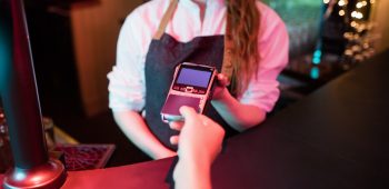 Customer making payment through credit card at counter in bar